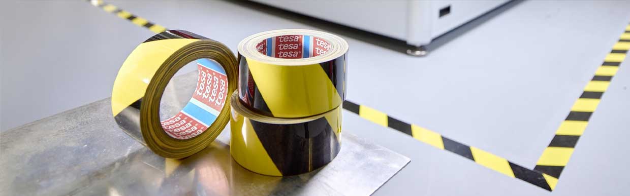 Industrial worker applying heavy-duty adhesive tape in a warehouse setting – showcasing {siteName} range of commercial tape solutions