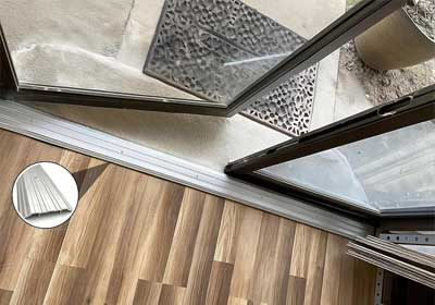 Premium door threshold trims in aluminium and brushed finishes displayed in a modern UK home interior